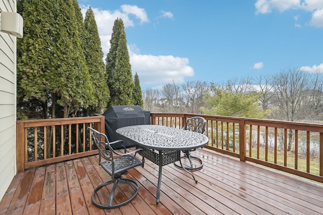 wooden terrace featuring grilling area and outdoor dining space