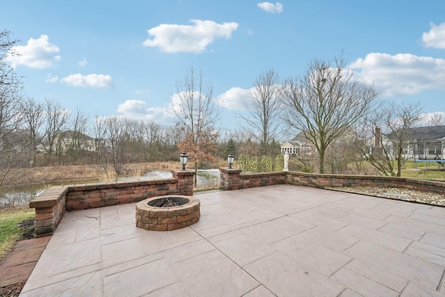 view of patio featuring a trampoline and an outdoor fire pit