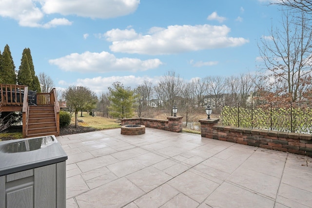 view of patio with an outdoor fire pit, stairway, and a wooden deck