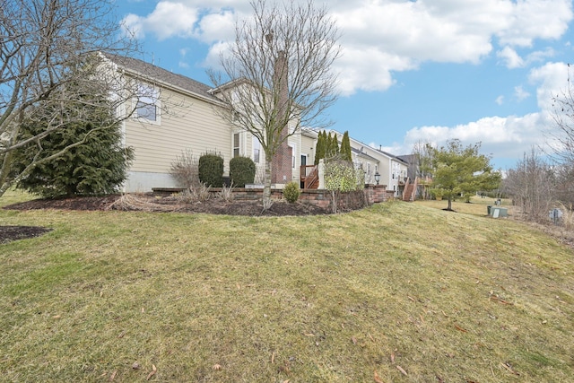 view of side of property with a yard and a chimney