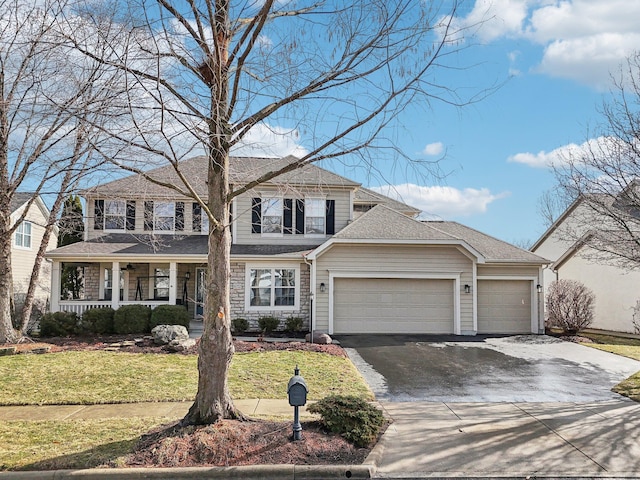 view of front of property featuring driveway, covered porch, an attached garage, and a front lawn