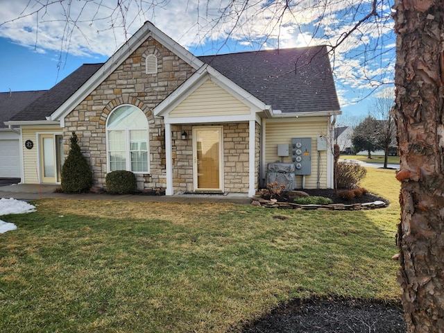 view of front of home with a garage, a shingled roof, and a front lawn