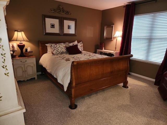 bedroom featuring light carpet and baseboards