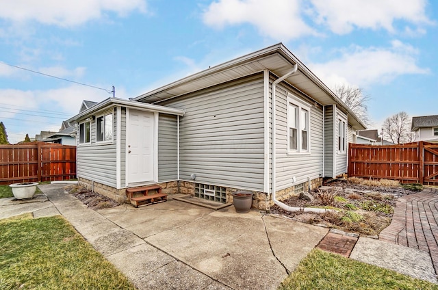 back of property with entry steps, a patio, and fence private yard