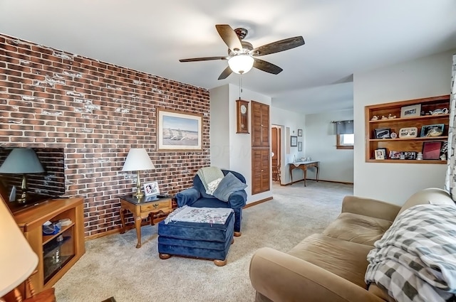 living room with ceiling fan, brick wall, carpet, and an accent wall