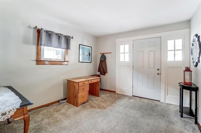 foyer with baseboards and light colored carpet