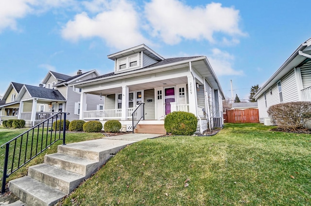 view of front of property featuring a porch, fence, a front lawn, and central AC unit