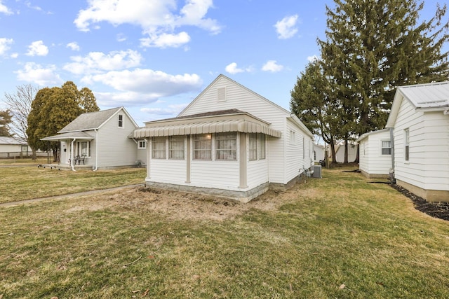 rear view of property featuring central AC and a yard