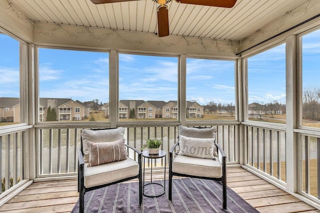 sunroom / solarium featuring ceiling fan, wooden ceiling, and a residential view