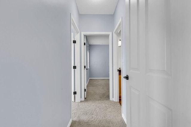 corridor featuring carpet flooring and baseboards