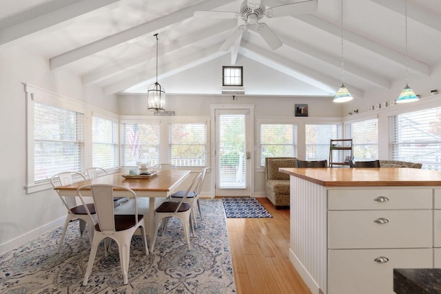 dining area featuring vaulted ceiling with beams, a ceiling fan, light wood-style flooring, and baseboards