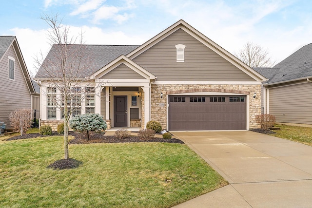 view of front of house with driveway, stone siding, roof with shingles, an attached garage, and a front yard