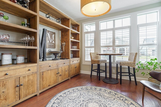 interior space featuring baseboards, hardwood / wood-style flooring, and crown molding