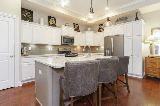 kitchen with appliances with stainless steel finishes, tasteful backsplash, dark wood finished floors, and ornamental molding