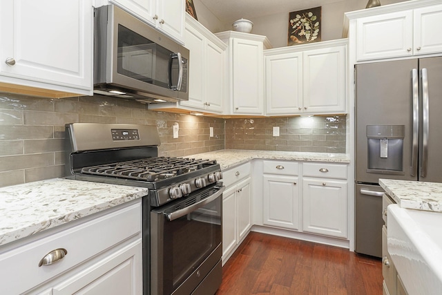 kitchen with decorative backsplash, appliances with stainless steel finishes, white cabinets, and dark wood-style flooring