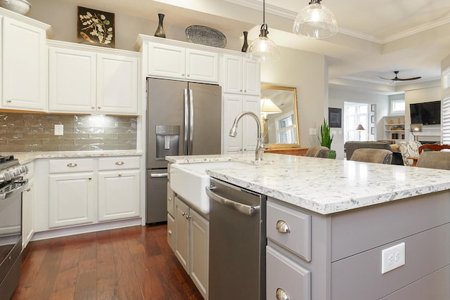 kitchen with light stone counters, stainless steel appliances, dark wood-type flooring, open floor plan, and crown molding