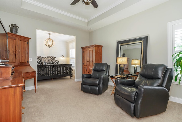 sitting room with a tray ceiling, a healthy amount of sunlight, light colored carpet, and crown molding