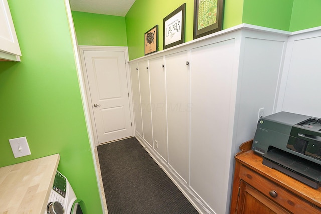 mudroom featuring wainscoting, carpet flooring, and a decorative wall