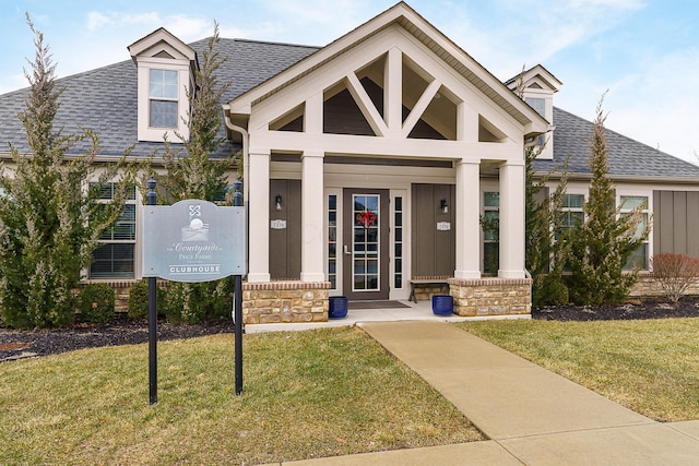 exterior space featuring a front lawn, roof with shingles, and a porch