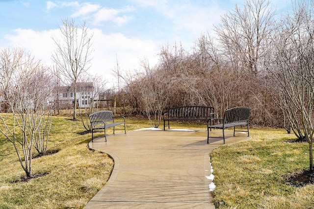 view of property's community featuring a lawn and a patio area