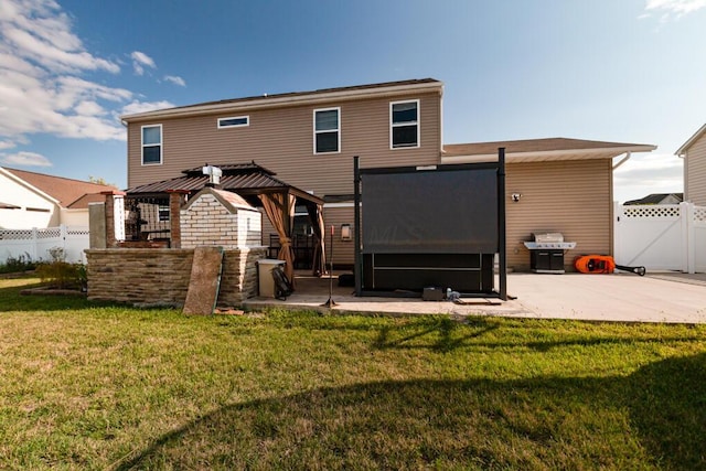 rear view of property featuring a gazebo, a yard, a patio, and fence