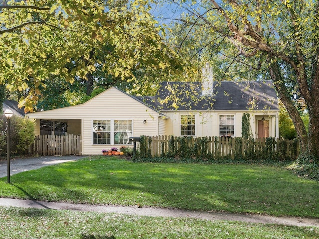 view of front facade with a chimney, a carport, a fenced front yard, and a front yard