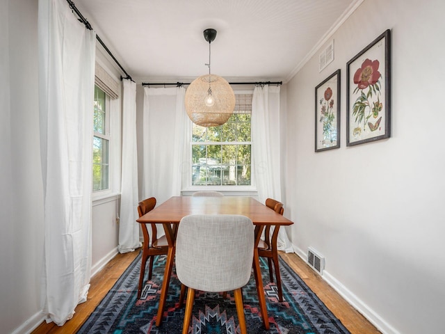 dining room with baseboards, visible vents, and wood finished floors