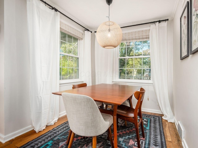 dining area with visible vents, light wood-style flooring, and baseboards