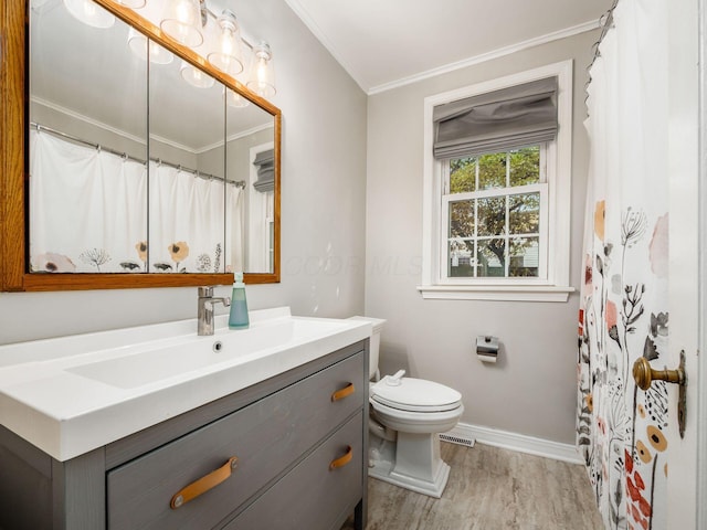 bathroom featuring toilet, wood finished floors, vanity, visible vents, and crown molding