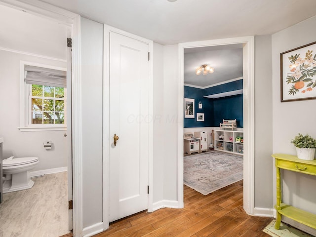 hallway featuring wood finished floors and baseboards