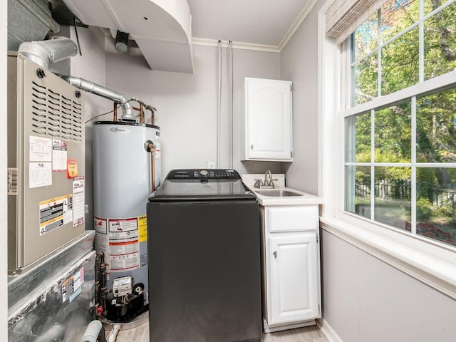 laundry room featuring a sink, washer / dryer, water heater, and cabinet space