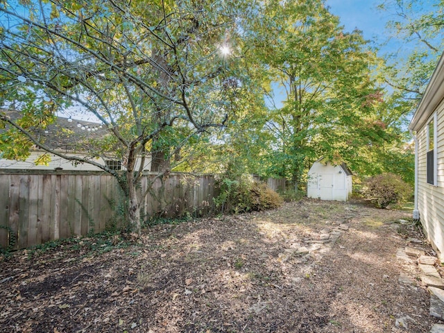 view of yard with fence, an outdoor structure, and a shed