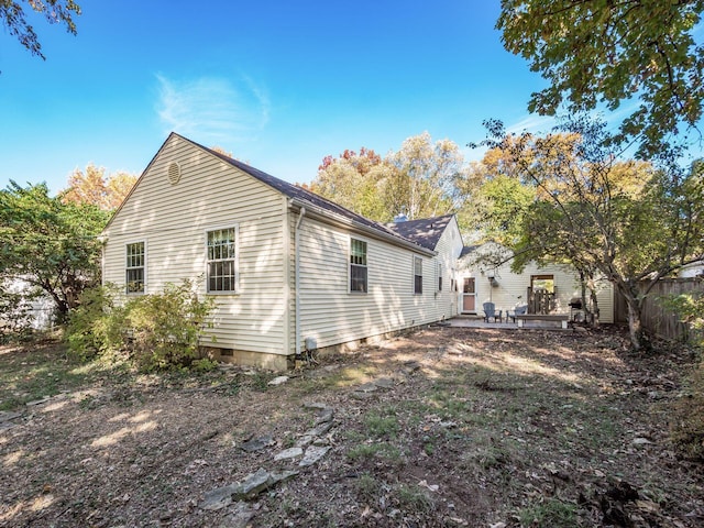 view of side of home featuring crawl space and fence