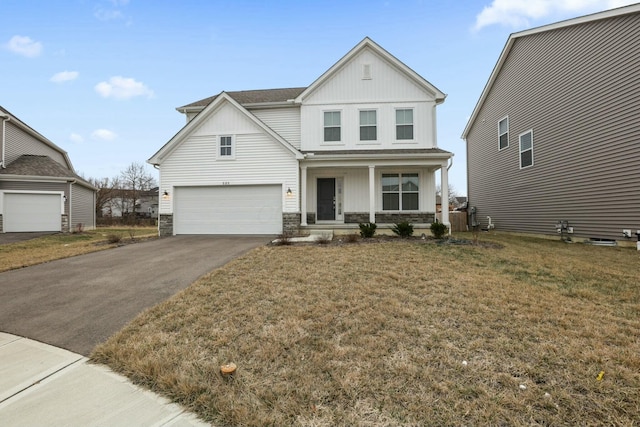 view of front of property with a porch, aphalt driveway, a garage, stone siding, and board and batten siding