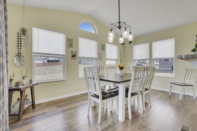 dining space with wood finished floors, visible vents, baseboards, vaulted ceiling, and an inviting chandelier