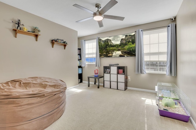 sitting room featuring carpet flooring, a ceiling fan, and baseboards