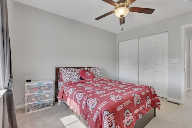 carpeted bedroom with a closet, visible vents, ceiling fan, and baseboards