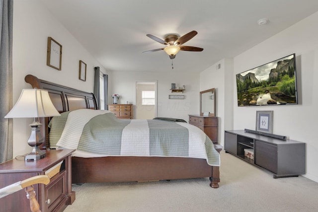 bedroom featuring connected bathroom, a ceiling fan, and light colored carpet