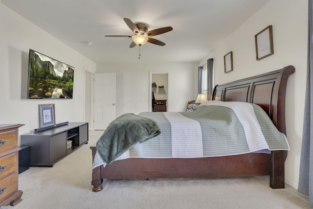 bedroom featuring ceiling fan, a spacious closet, and light colored carpet