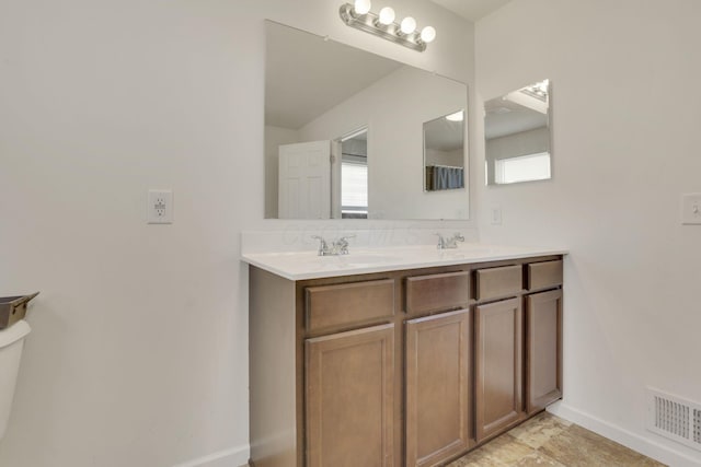 full bathroom featuring visible vents, a sink, baseboards, and double vanity