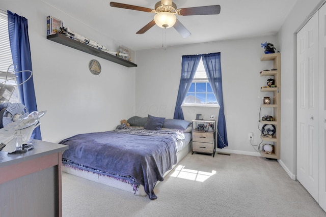 bedroom with a closet, carpet flooring, ceiling fan, and baseboards