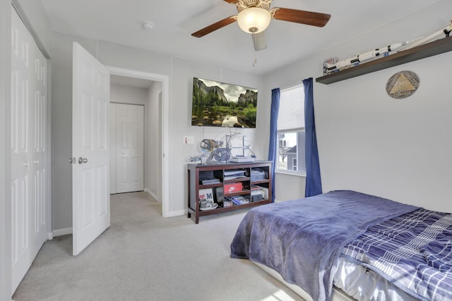 carpeted bedroom featuring ceiling fan, a closet, and baseboards