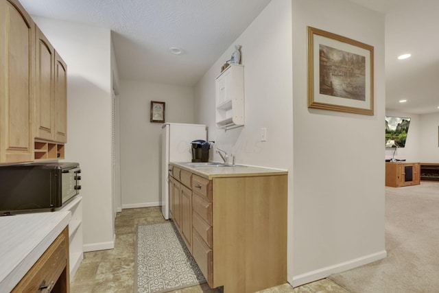 kitchen featuring recessed lighting, black microwave, light countertops, and a sink