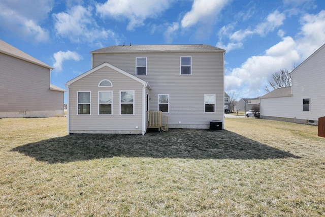 rear view of property featuring central AC and a yard