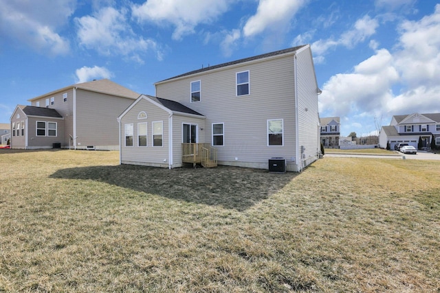 rear view of house featuring central air condition unit and a yard