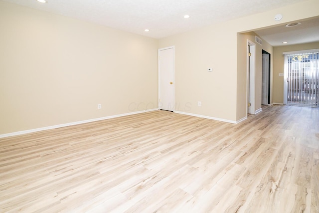 empty room with recessed lighting, visible vents, light wood finished floors, and baseboards