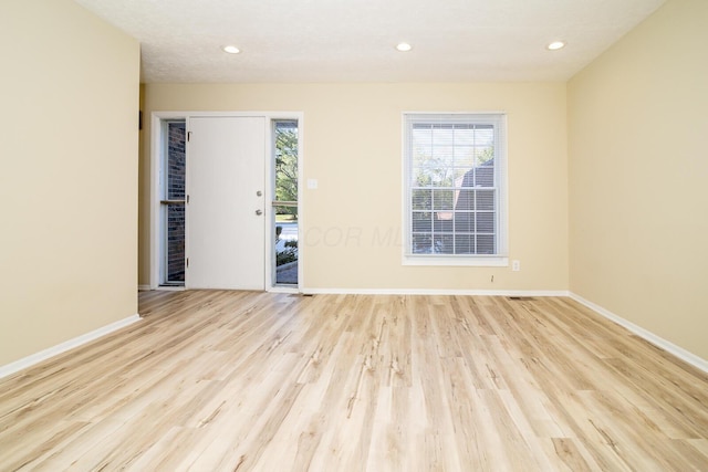 empty room with recessed lighting, wood finished floors, and baseboards