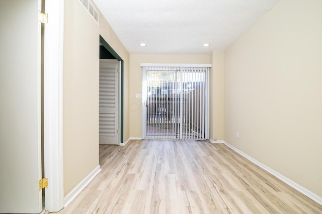 spare room with light wood finished floors, recessed lighting, visible vents, and baseboards