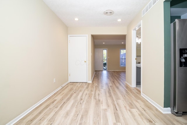 hall with recessed lighting, baseboards, visible vents, and light wood finished floors