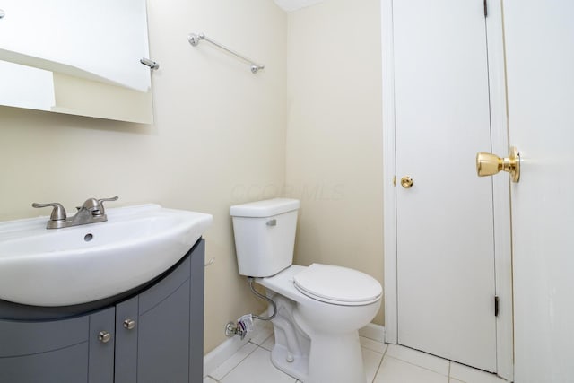 bathroom with tile patterned flooring, baseboards, vanity, and toilet